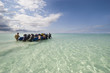 zanzibar diving tourists walking inflatable boat out of shallow zanzibar diving tourists walking inflatable boat out of shallow