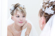 Photo: young bride looks into a big mirror young bride looks into a big mirror