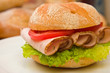 Fresh kaiser bun with turkey breast, lettuce and tomatoes Fresh kaiser bun with turkey breast, lettuce and tomatoes