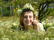 Smiling girl with a chaplet on a head speaks on a telephone. Smiling girl with a chaplet on a head speaks on a telephone.