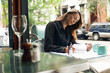 Woman Writing at Sidewalk Cafe