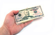 The hand stretching a pack of dollars