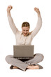 Young woman with laptop, raising her arms in victory