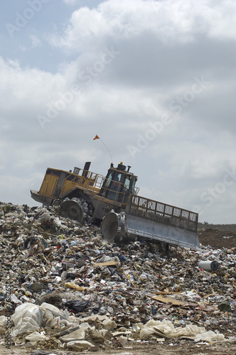 Photo: Digger working at landfill site Digger working at landfill site