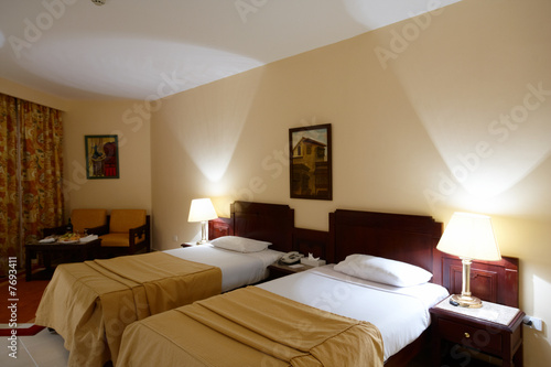 Two beds with lamps and table with wine Two beds with lamps and table with wine