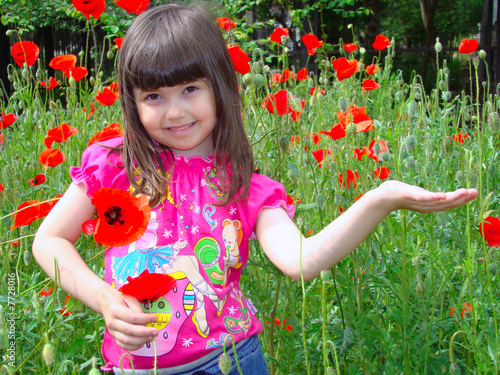 Photo: Girl with brown eyes on the field of red poppies. Girl with brown eyes on the field of red poppies.