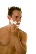 Young man applying shaving cream to his face Young man applying shaving cream to his face