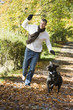 Photo: Man exercising dog in woodland Man exercising dog in woodland