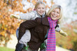 Mother giving daughter piggy back ride