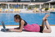 Jeune fille travaille au bord de la piscine