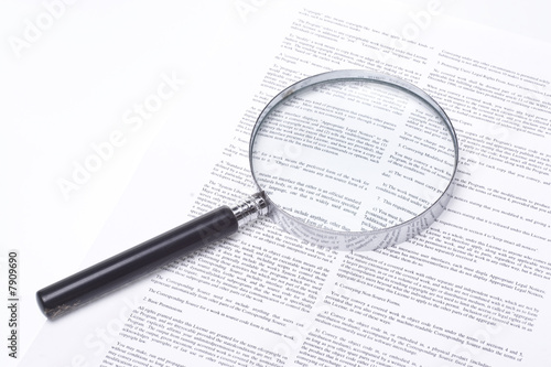 Magnifying glass lying on a legal contract