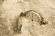 Vintage pocket clock buried in sand. Lost time concept.