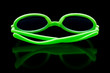 Bright green sunglasses on shiny black background