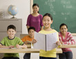 Portrait of a young girl reading report to classmates