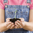 Young woman holding seedling and soil