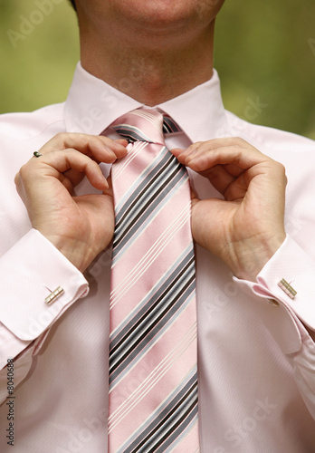 Photo: Man tying necktie Man tying necktie