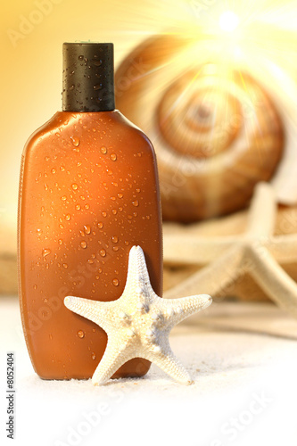 Suntan lotion with seashells on white