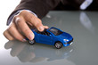 hand holding small blue car