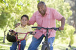Grandfather and grandson on bikes outdoors smiling