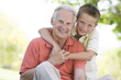 Grandfather and grandson outdoors smiling