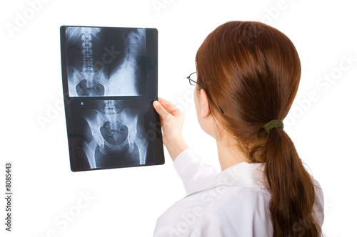 Photo: Female doctor examining a pelvis x ray Female doctor examining a pelvis x ray