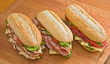 Turkey, ham and salami sandwiches on a wooden surface