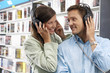 Photo: Young couple wearing headphones, listening to CDs in record shop, smiling Young couple wearing headphones, listening to CDs in record shop, smiling
