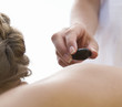 A young woman receiving a hot stone holistic treatment