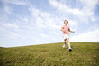 A young girl running across a hill