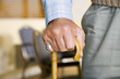 An elderly man holding a walking stick