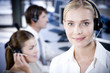 Smiling businesswoman looking at the camera wearing a call centre headset