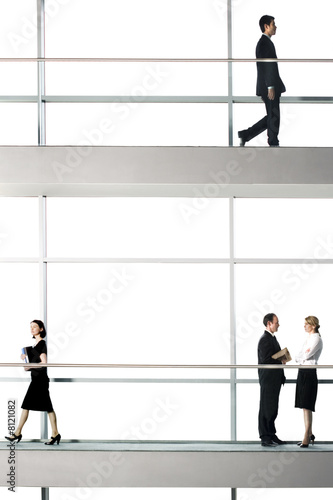 Photo: Office workers walking around modern office building Office workers walking around modern office building