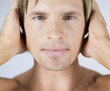 A male nude, hands over ears