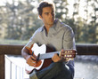 A young man playing a guitar