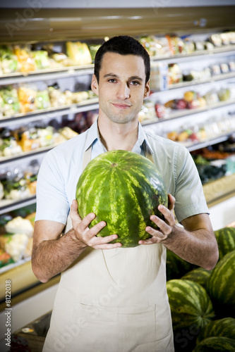 Photo: Portrait of a supermarket shop assistant holding a watermelon Portrait of a supermarket shop assistant holding a watermelon
