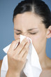 A young woman blowing her nose