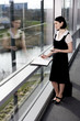 Photo: Businesswoman or secretary with an appointments diary, staring out of the window Businesswoman or secretary with an appointments diary, staring out of the window