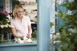 Woman florist creating a bouquet of pink and white roses