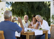 Foto: A group of senior couples at a restaurant, man taking picture with digital camera A group of senior couples at a restaurant, man taking picture with digital camera