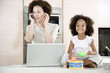 Stressed mother working from home while daughter plays a toy drum