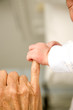 A baby's hand holding their grandparent's finger