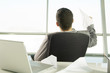 A businessman sitting at a desk making paper airplanes