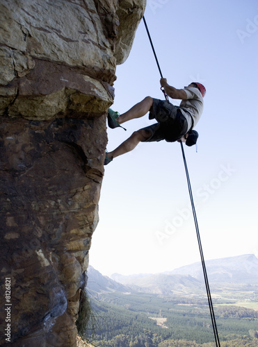Photo: A climber climbing a rock face A climber climbing a rock face