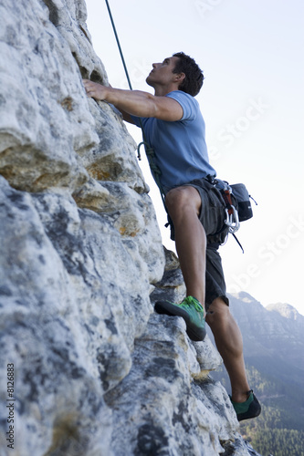 Photo: A climber climbing a rock face A climber climbing a rock face