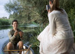 Foto: Young woman taking a photo of her partner's fishing success Young woman taking a photo of her partner's fishing success