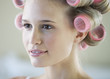 A young woman with her hair in curlers
