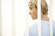 Portrait of a young man behind bars