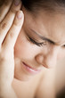 Woman with toothache or headache, holding her hand to her temple