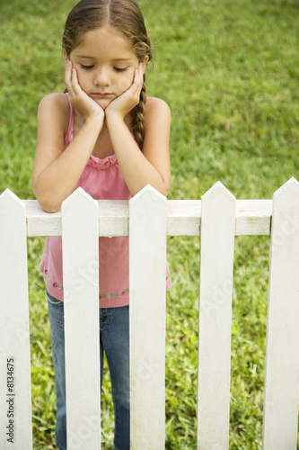 Photo: sad little girl leaning on fence sad little girl leaning on fence