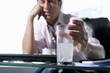Photo: Young businessman with head in hand holding glass of water and soluble tablets, close-up of hand (differential focus) Young businessman with head in hand holding glass of water and soluble tablets, close-up of hand (differential focus)